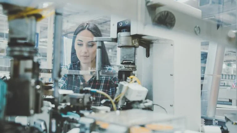 Female technician working with manufacturing equipment in a factory